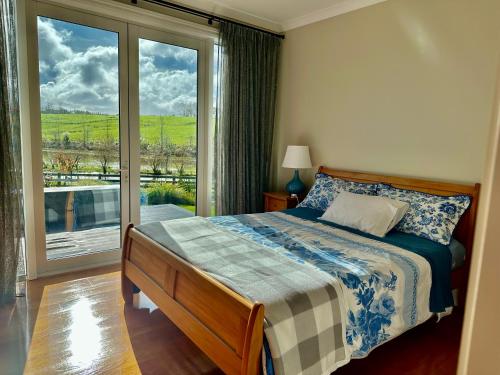 a bedroom with a bed and a window with a view at Lifestyle Guesthouse in Dairy Flat