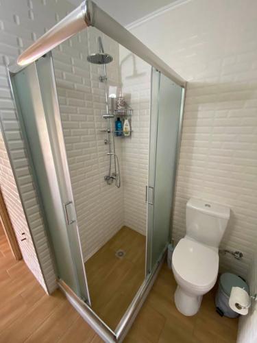 a bathroom with a toilet and a glass shower at Xristina's Experience in Pylos
