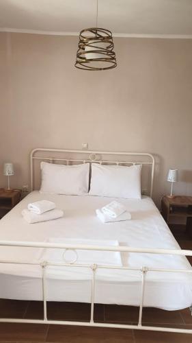 a large white bed with two white towels on it at Xristina's Experience in Pylos