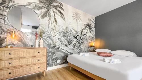 a bedroom with a wall mural of palm trees at HOMEY Moorea - Hyper-centre/ Proche Genève/ wifi in Annemasse