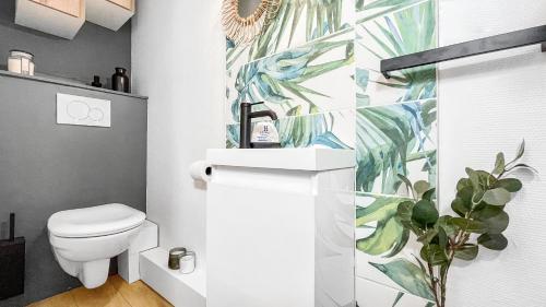 ein Badezimmer mit einem weißen WC und einer Pflanze in der Unterkunft HOMEY Moorea - Hyper-centre/ Proche Genève/ wifi in Annemasse
