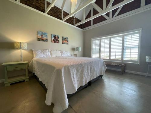 1 dormitorio con 1 cama con colcha blanca en Ocean Mist, Port Edward, en Port Edward