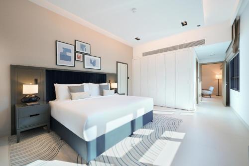 a bedroom with a large bed and a living room at Cheval Maison - The Palm in Dubai