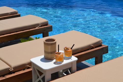 dos bebidas en una mesa junto a una piscina en Charakas Horizon, en Gavrion
