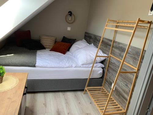 a bedroom with a bed with a ladder next to it at Domek Mirage Garden in Trzęsacz