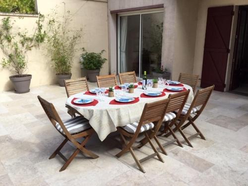 une table en bois avec des chaises et un chiffon de table. dans l'établissement Arcachon Villa aux Abatilles, à Arcachon