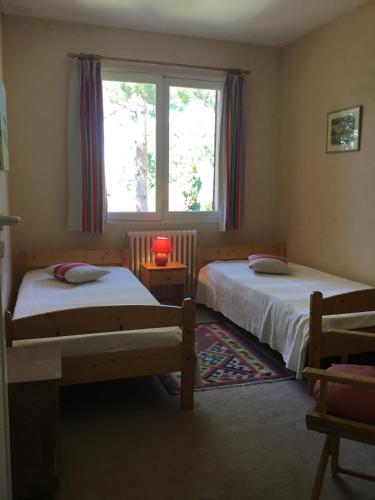 une chambre avec deux lits et une fenêtre dans l'établissement Arcachon Villa aux Abatilles, à Arcachon