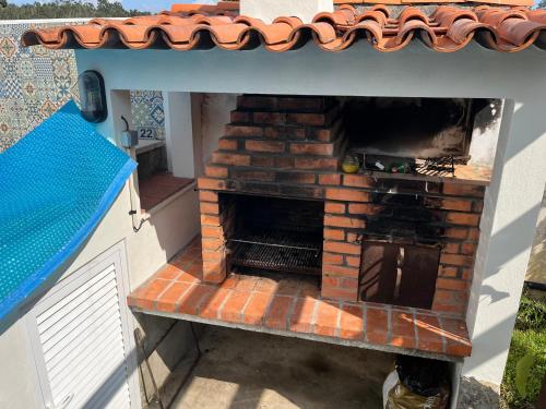 an outdoor brick oven in a toy house at Citrus Tree House, private pool and garden. in Angeja