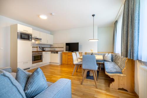 a kitchen and living room with a table and chairs at Aparthotel Jägerheim in Flachau