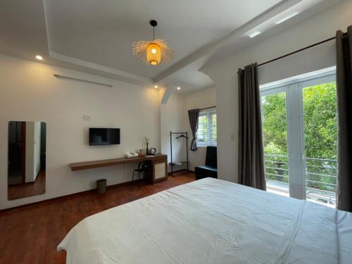 a bedroom with a large white bed and a window at Lynk Stay Hoian in Hoi An