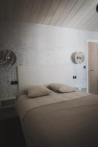 a bedroom with a bed with two pillows on it at Logis de l'Héronière in Salles-sur-Mer