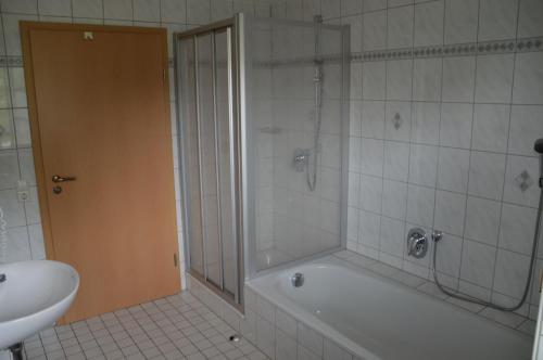 een badkamer met een douche, een bad en een wastafel bij Ferienhof Hilebrand in Kressbronn am Bodensee