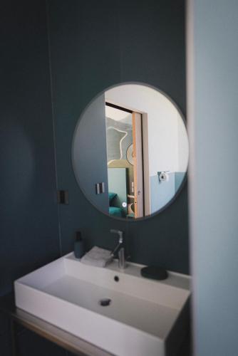 a bathroom with a white sink and a mirror at Logis de l'Héronière in Salles-sur-Mer
