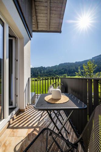 a patio with a table and chairs on a balcony at Aparthotel Jägerheim in Flachau