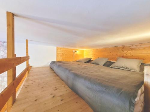 a large bed in a room with a wooden wall at Apartmán Pec pod Sněžkou - Cihlářka in Pec pod Sněžkou