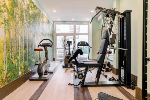 a gym with tread machines and a wall mural at AluaSun Helios Beach - All Inclusive in Obzor