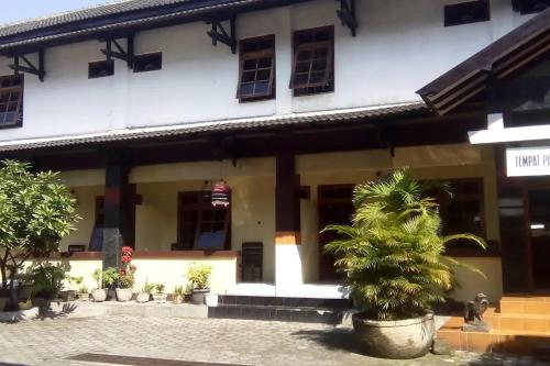 a building with palm trees in front of it at Hotel Merak Indah in Klaten