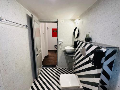 a bathroom with a black and white checkered floor at AnandMai Ghar - A Homestay in Gwalior in Gwalior