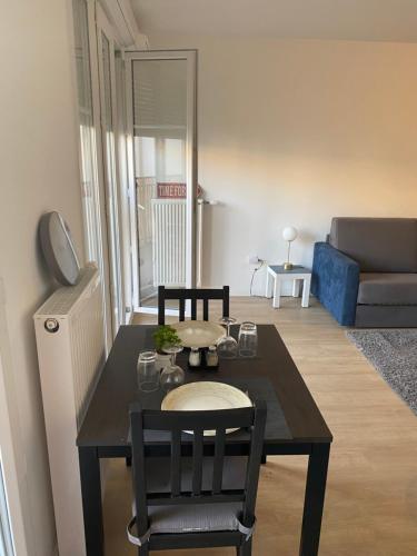 a living room with a table and chairs and a couch at BEAU STUDIO NEUF AVEC TERRASSE in Le Blanc-Mesnil