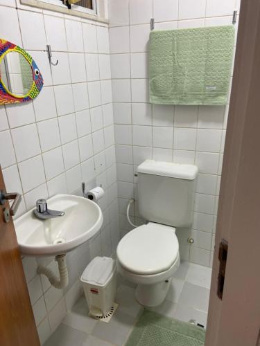 a bathroom with a toilet and a sink at Vilage beira-mar Itacimirim in Camaçari