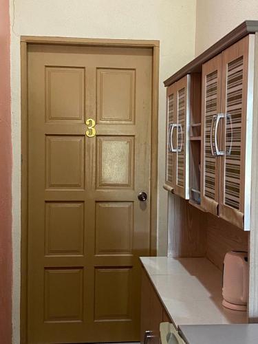 a door in a kitchen next to a kitchen counter at Bilik Harian Pengkalan Chepa in Pengkalan Cepa