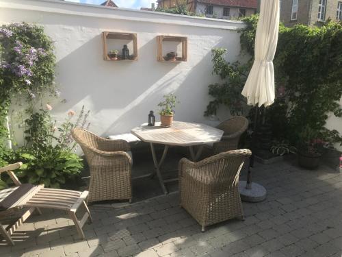 a patio with a table and chairs and an umbrella at *****elegant feriebolig i hjertet af Kerteminde in Kerteminde