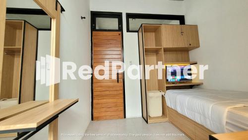 - une chambre avec un lit et une télévision dans l'établissement Griya Nawastika At Jakal KM 8 Mitra RedDoorz, à Kejayan