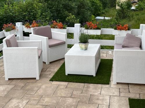 a group of white wicker chairs and tables on a patio at Dom pod kogutem in Laliki