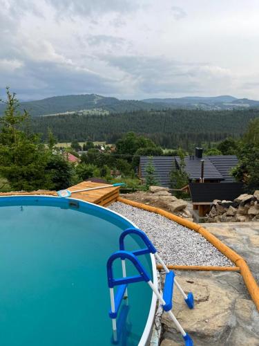 a blue swimming pool with a hose around it at Dom pod kogutem in Laliki