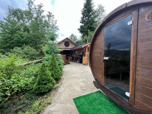 a small wooden building with a yard with green grass at Dom pod kogutem in Laliki