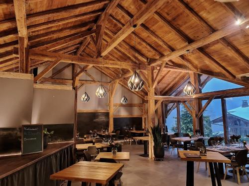 モルジヌにあるLe PasSionNantの木製の天井、テーブルと椅子のあるレストラン