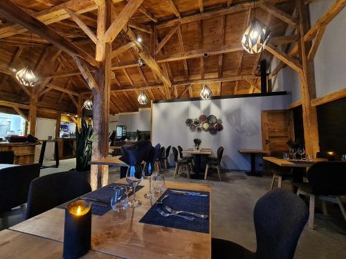 a dining room with tables and chairs and wooden ceilings at Le PasSionNant in Morzine