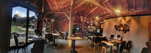 a restaurant with wooden ceilings and tables and chairs at Le PasSionNant in Morzine