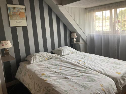 a bedroom with a bed with a striped wall at 'Onder-dak' 2-persoons appartement in Zandvoort