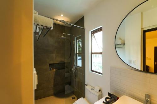 a bathroom with a shower and a mirror at J Boutique Hotel El Nido in El Nido