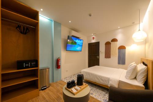 Habitación de hotel con cama y TV en J Boutique Hotel El Nido en El Nido