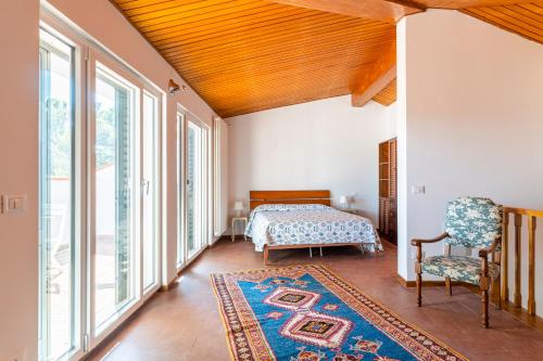 a bedroom with a bed and a chair and a rug at Quercianella Lovely Villa near the Sea W/Parking! in Quercianella