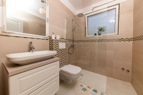 a bathroom with a toilet and a sink and a shower at Holiday Home Ninna in Crikvenica