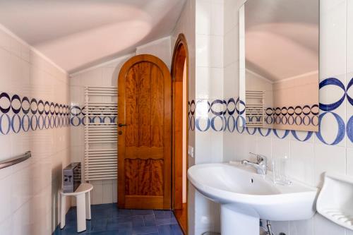 a bathroom with a sink and a wooden door at Quercianella Lovely Villa near the Sea W/Parking! in Quercianella