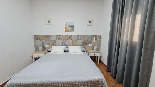 a bedroom with two beds and a window at Hostal Canalejas in Cádiz