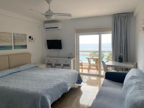 a bedroom with two beds and a view of the ocean at Apartahotel CHINASOL con Parking y Desayuno in Almuñécar