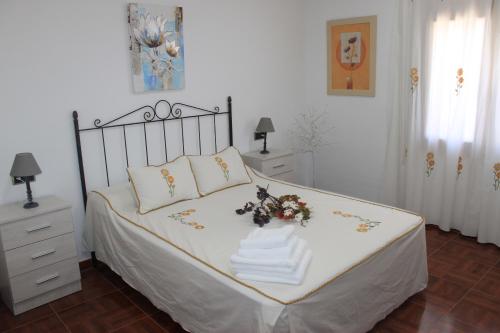 a bedroom with a bed with a flower arrangement on it at Casa Mirasierra in Mota del Cuervo