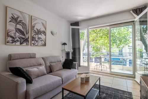 un salon avec un canapé et une table dans l'établissement 29 CARNOT - Chaleureux appartement avec balcon - centre ville, à Cannes