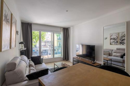 un salon avec un canapé et une table dans l'établissement 29 CARNOT - Chaleureux appartement avec balcon - centre ville, à Cannes