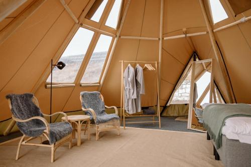 a room in a tent with two beds and a table and chairs at IceHotel in Jukkasjärvi
