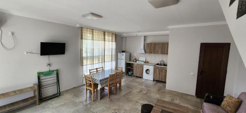 a living room with a table and a kitchen at Rio cottage apartment in Ureki