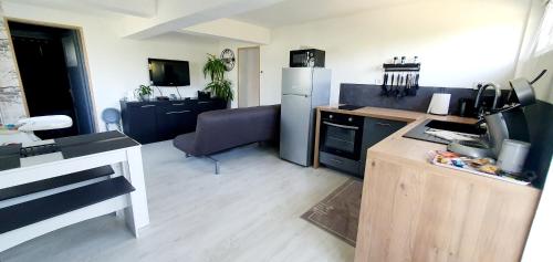 a kitchen with a refrigerator and a counter top at L'osmose in Coulogne