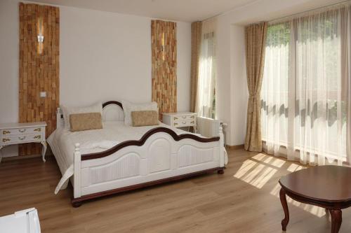 a bedroom with a white bed and a table at Стаи за гости RADEA in Devin