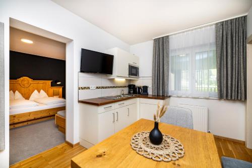 a kitchen and dining room with a table and a bed at Aparthotel Jägerheim in Flachau
