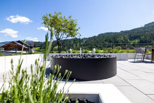 a patio with a fountain on top of a building at Aparthotel Jägerheim in Flachau